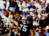 Howie Long Autographed Oakland Raiders 16x20 Holding Ball Up- Beckett Auth *Black